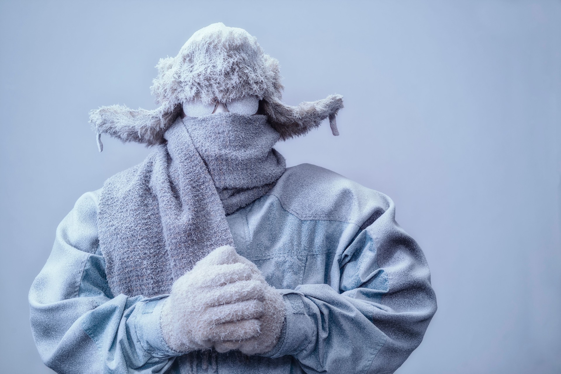 Man in parka, hat and scarf frozen from the cold