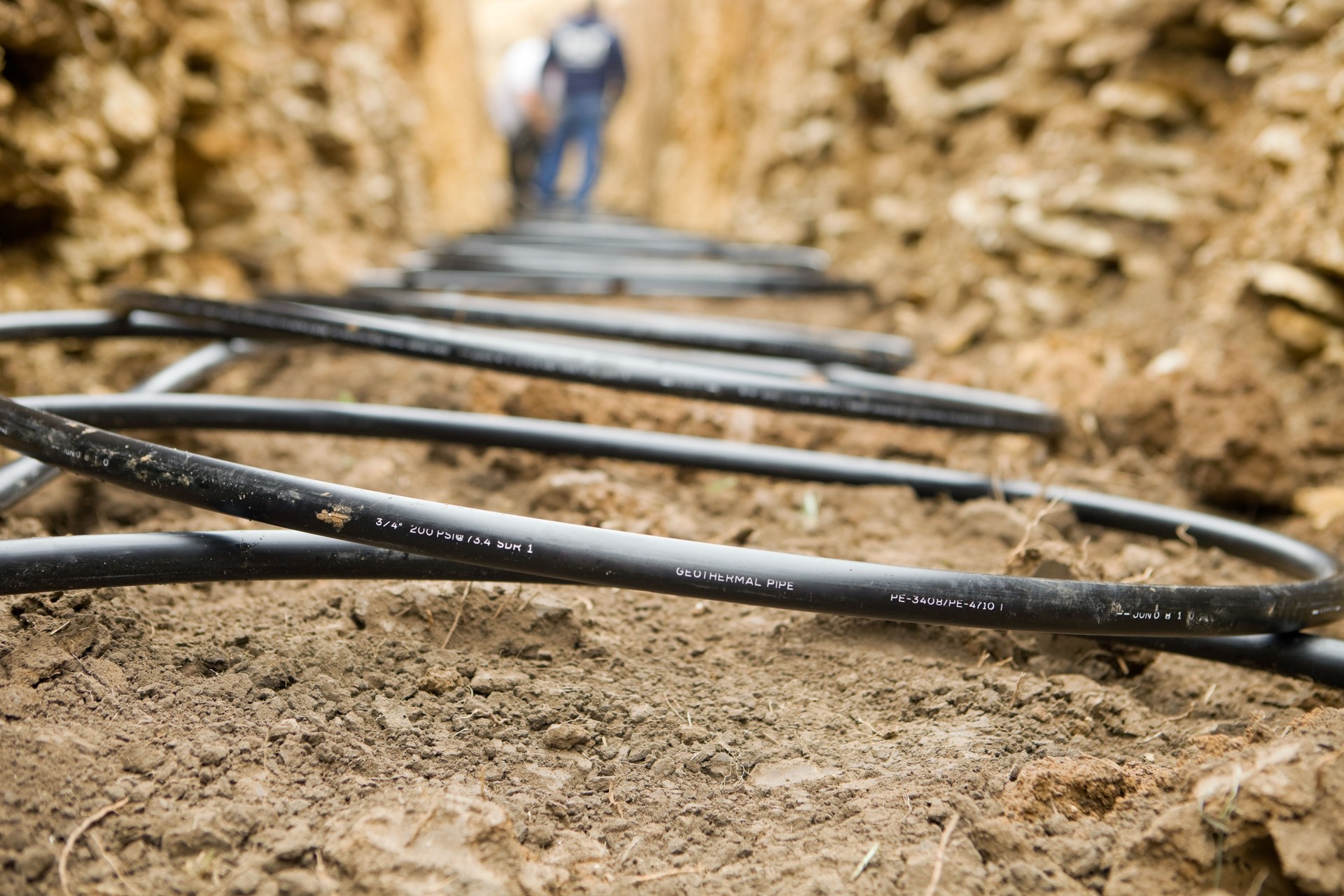 Workers Laying Geothermal Coils in an Underground Trench